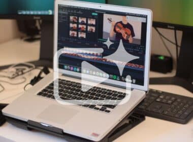 A professional laptop setup showing a video editing interface with a white play button and sparkle icon overlay, representing the best AI video generator and face swap video online tools of 2026.