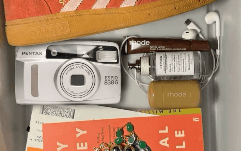 A lifestyle flat lay featuring a Pentax Espio 838G compact camera, representing the comeback of compact cameras and a digital detox lifestyle.