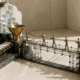 A brass sculpture contrasts blank content cards on a conveyor with people passing a detailed document across a glass bridge.